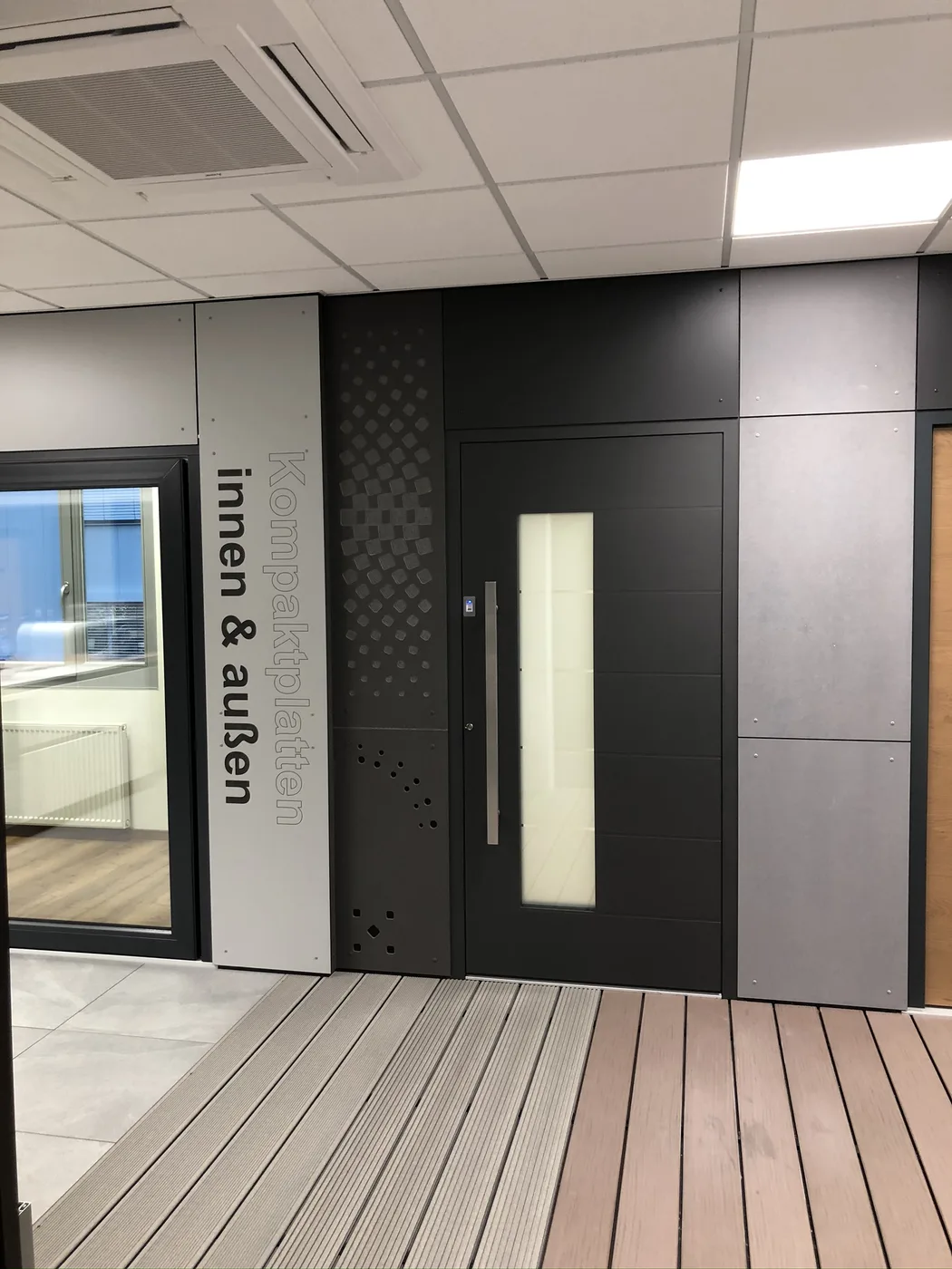 Musterwand mit Tür, Kompaktplatten und dekorativen Lochbildern